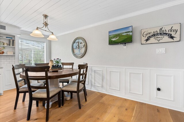 42 Cherry Hill Dr, Conroe, TX 77304 - dining area featuring ornamental molding, wooden ceiling, light wood-style flooring, and a wainscoted wall