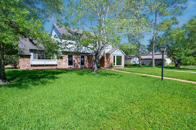 view of front of property featuring a front lawn and brick siding