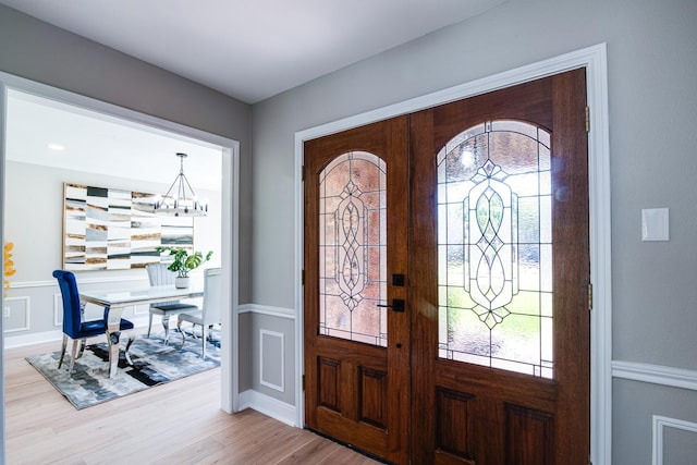 entrance foyer featuring french doors, healthy amount of natural light, and wainscoting