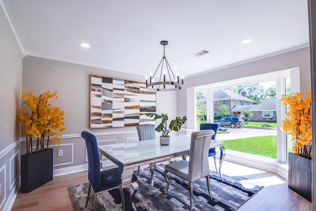 dining space with a chandelier, wood finished floors, crown molding, and recessed lighting