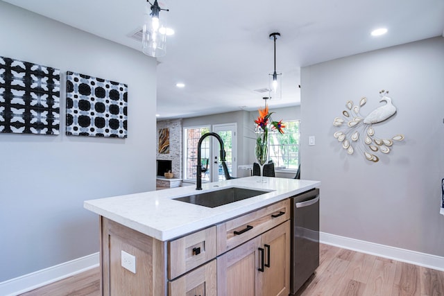 kitchen featuring a sink, light wood-style floors, baseboards, dishwasher, and recessed lighting