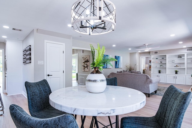 dining area featuring light wood finished floors, recessed lighting, and a chandelier