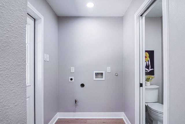 washroom featuring gas dryer hookup, electric dryer hookup, hookup for a washing machine, wood finished floors, and baseboards