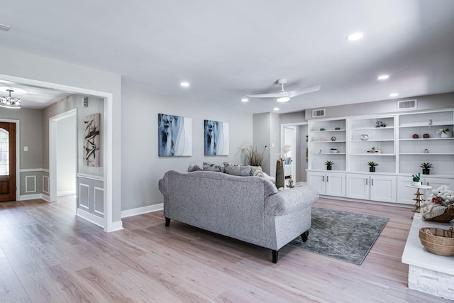 living area with light wood-style floors, recessed lighting, a chandelier, and ceiling fan