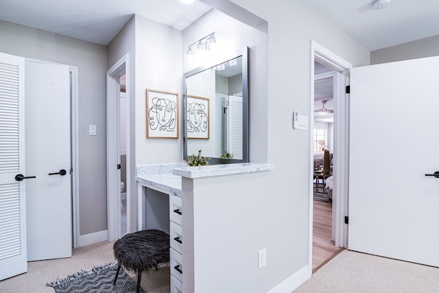 corridor featuring light carpet and baseboards