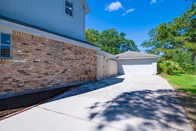 view of property exterior with driveway, a garage, and brick siding