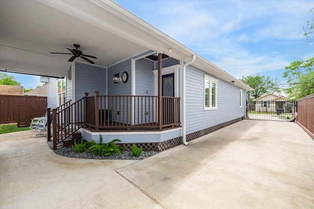 view of front facade featuring a ceiling fan, fence, and driveway