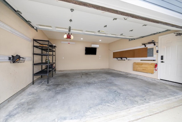 garage with a garage door opener and electric panel