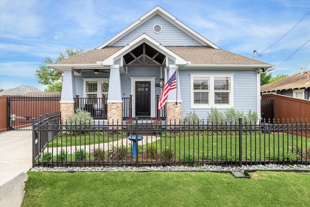 view of front of property featuring roof with shingles, a gate, and a porch