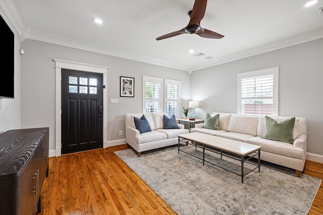 living room with ornamental molding, wood finished floors, ceiling fan, recessed lighting, and baseboards