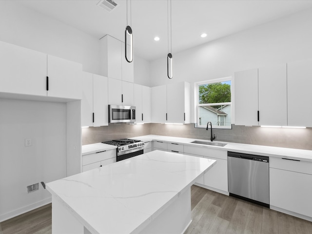 1264 Finnigan St, Houston, TX 77020 - kitchen featuring stainless steel appliances, a sink, light wood-style flooring, a kitchen island, and tasteful backsplash