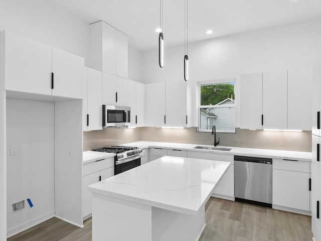 1264 Finnigan St, Houston, TX 77020 - kitchen with stainless steel appliances, a sink, light wood-type flooring, a center island, and white cabinets