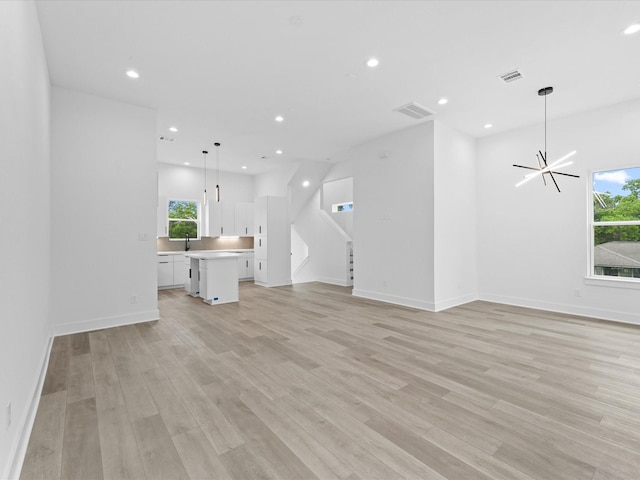 1264 Finnigan St, Houston, TX 77020 - unfurnished living room with healthy amount of natural light, light wood-style floors, a chandelier, and recessed lighting