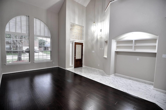 foyer featuring baseboards and wood finished floors