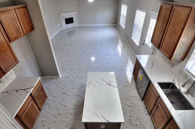 unfurnished living room featuring a sink, a fireplace, and baseboards