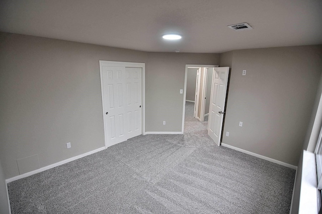 unfurnished bedroom with carpet flooring, baseboards, and a closet