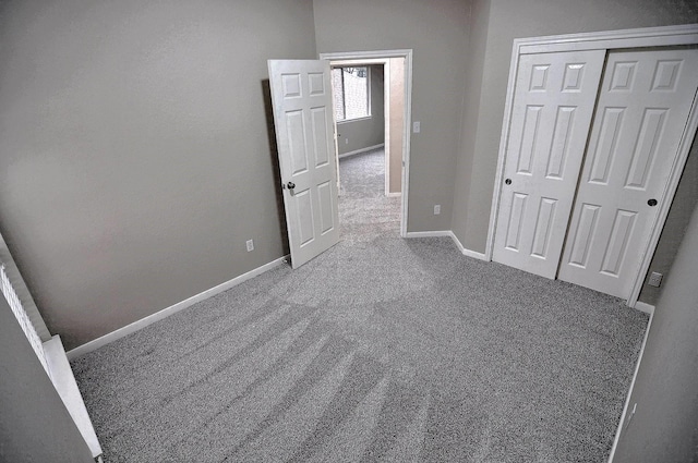 unfurnished bedroom with carpet floors, baseboards, and a closet