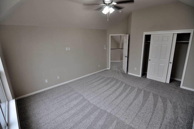 unfurnished bedroom featuring vaulted ceiling, carpet floors, baseboards, a closet, and ceiling fan