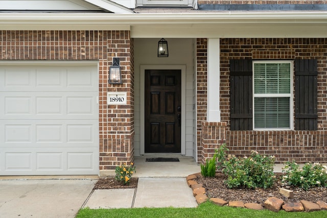 18910 S Sapling Oaks Pl, Magnolia, TX 77355 - view of exterior entry featuring brick siding, a porch, and an attached garage