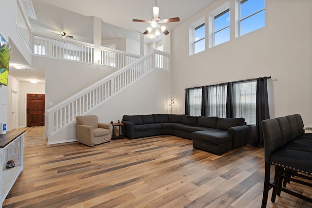 18910 S Sapling Oaks Pl, Magnolia, TX 77355 - living area with a ceiling fan, a towering ceiling, light wood-style flooring, and stairway