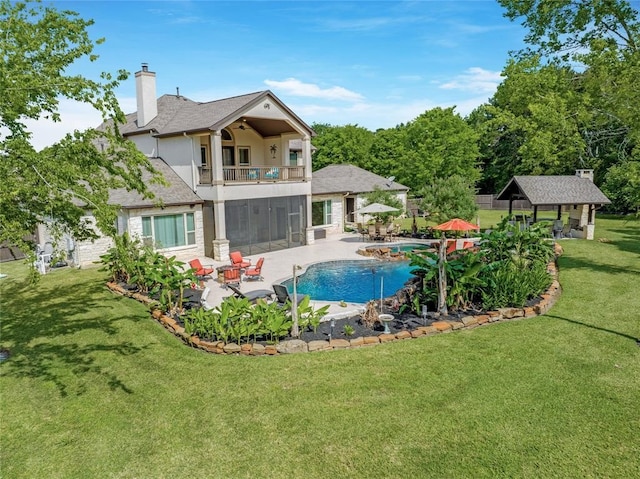 14710 Turquoise Ct, Willis, TX 77378 - back of property with a balcony, stucco siding, a patio area, a chimney, and a lawn