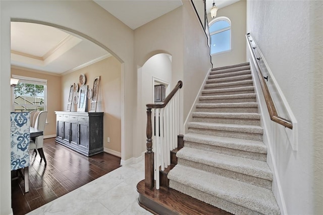 14710 Turquoise Ct, Willis, TX 77378 - staircase with plenty of natural light, ornamental molding, baseboards, a raised ceiling, and arched walkways