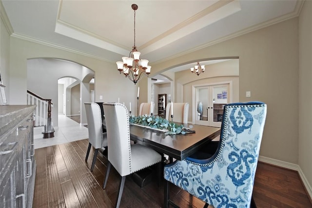 14710 Turquoise Ct, Willis, TX 77378 - dining area with a chandelier, arched walkways, a tray ceiling, ornamental molding, and stairway