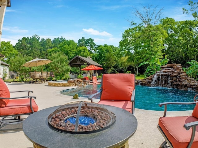 14710 Turquoise Ct, Willis, TX 77378 - community pool featuring a fire pit, a patio, a hot tub, and view of wooded area