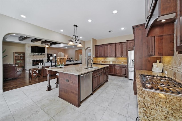 14710 Turquoise Ct, Willis, TX 77378 - kitchen with arched walkways, stainless steel appliances, open floor plan, ceiling fan, and recessed lighting