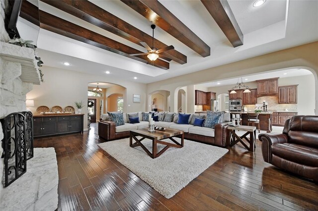 14710 Turquoise Ct, Willis, TX 77378 - living area featuring arched walkways, a ceiling fan, beam ceiling, recessed lighting, and dark wood-style flooring