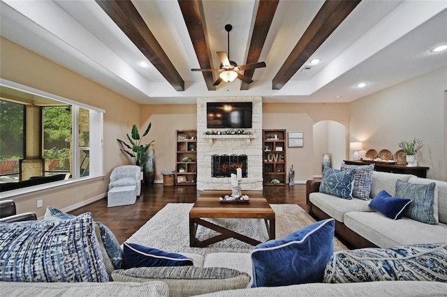 14710 Turquoise Ct, Willis, TX 77378 - living area featuring arched walkways, wood finished floors, ceiling fan, baseboards, and a stone fireplace
