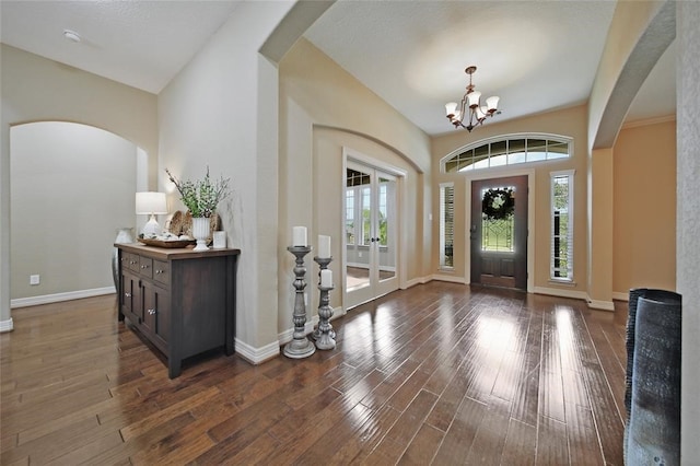 14710 Turquoise Ct, Willis, TX 77378 - entryway featuring wood finished floors, a chandelier, baseboards, and arched walkways