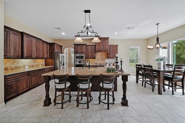 14710 Turquoise Ct, Willis, TX 77378 - kitchen with appliances with stainless steel finishes, a sink, decorative backsplash, a breakfast bar, and recessed lighting