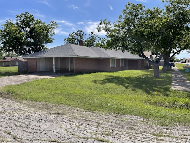 441 E Clark St, Bartlett, TX 76511 - view of front of property featuring driveway, an attached carport, a front yard, a chimney, and brick siding