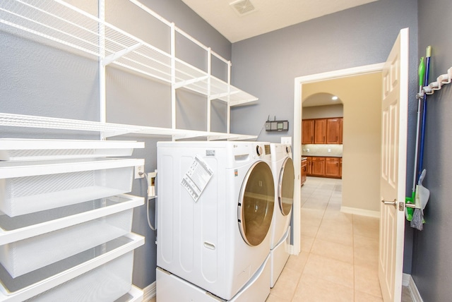 8502 Calverton Pines Ln, Houston, TX 77095 - laundry area with independent washer and dryer, light tile patterned floors, arched walkways, and baseboards