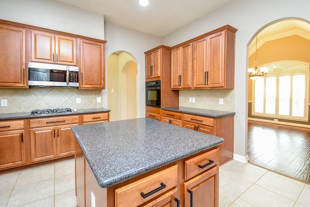 8502 Calverton Pines Ln, Houston, TX 77095 - kitchen with appliances with stainless steel finishes, arched walkways, light tile patterned floors, brown cabinetry, and recessed lighting