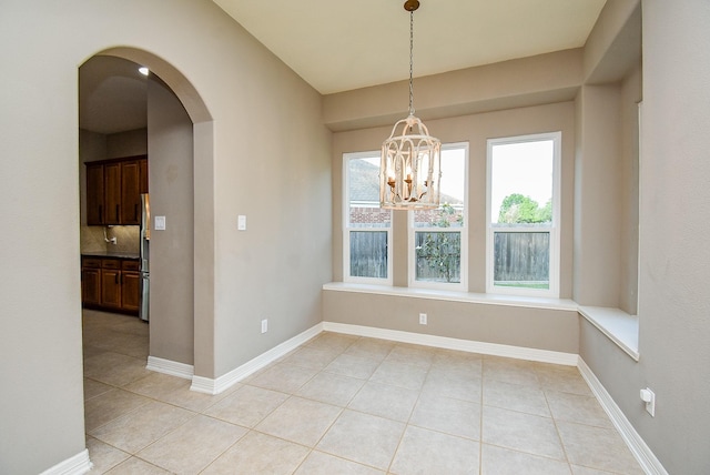 8502 Calverton Pines Ln, Houston, TX 77095 - unfurnished dining area with light tile patterned floors, arched walkways, a chandelier, and baseboards