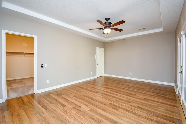 8502 Calverton Pines Ln, Houston, TX 77095 - unfurnished room featuring a raised ceiling, a ceiling fan, light wood finished floors, and baseboards