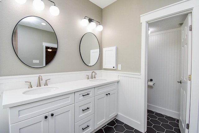 8502 Calverton Pines Ln, Houston, TX 77095 - full bath featuring double vanity, a wainscoted wall, and tile patterned floors