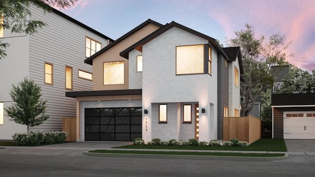 contemporary home with brick siding, fence, driveway, and a garage