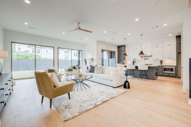 living room featuring light wood-style flooring, recessed lighting, and a ceiling fan