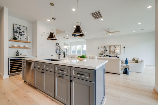 kitchen featuring a sink, gray cabinetry, light wood-style floors, dishwasher, and recessed lighting