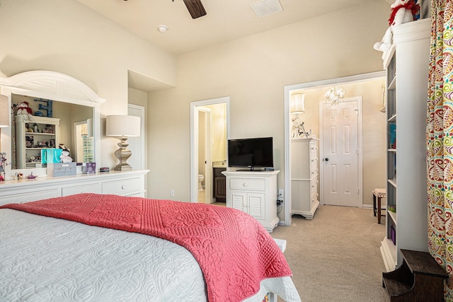 bedroom with light colored carpet, ensuite bath, and ceiling fan