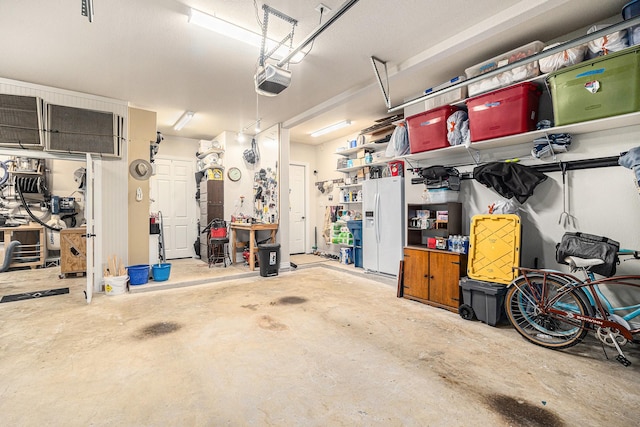 garage featuring white refrigerator with ice dispenser and a garage door opener
