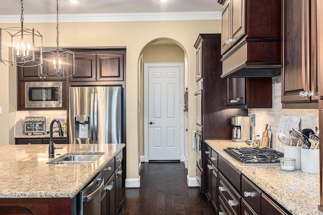kitchen featuring appliances with stainless steel finishes, a sink, baseboards, dark brown cabinetry, and a chandelier
