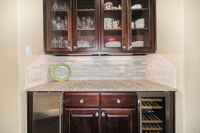 indoor dry bar featuring wine cooler, freestanding refrigerator, backsplash, and a textured wall