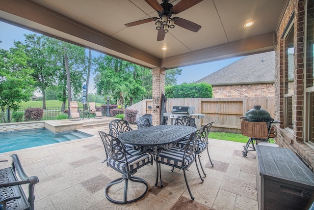 view of patio with outdoor dining space, a ceiling fan, a fenced backyard, and grilling area