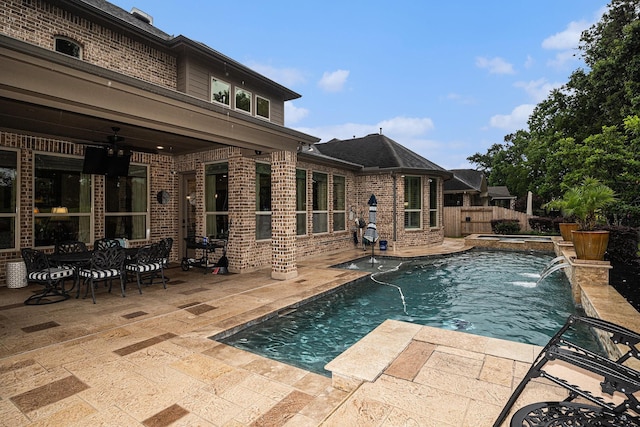 view of swimming pool featuring a patio area, a fenced backyard, a ceiling fan, and a pool with connected hot tub