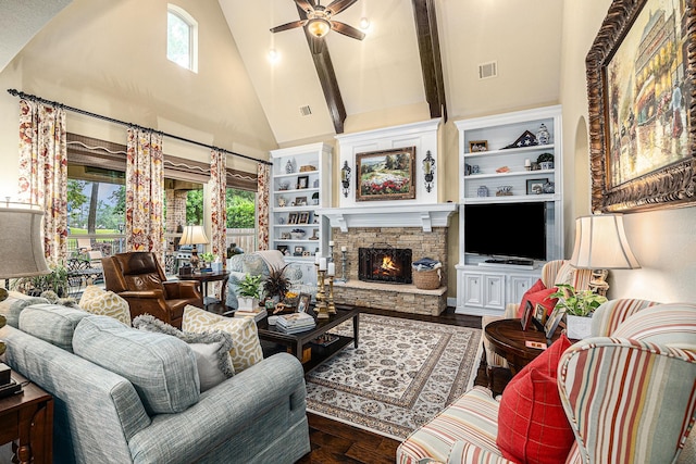 living area featuring high vaulted ceiling, healthy amount of natural light, a ceiling fan, a fireplace, and built in shelves