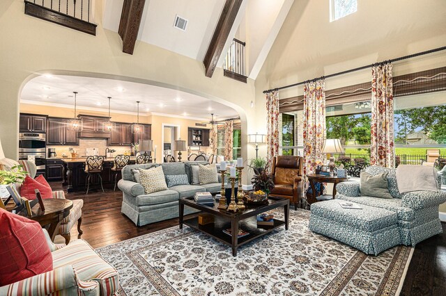 living area featuring arched walkways, high vaulted ceiling, dark wood finished floors, and beamed ceiling